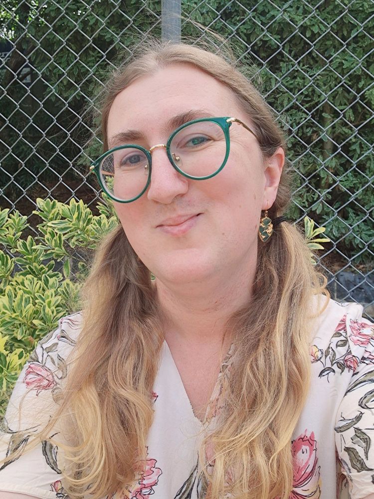 Jasmine in a floral dress with her hair in long pigtails looking maximally cute and innocent.  