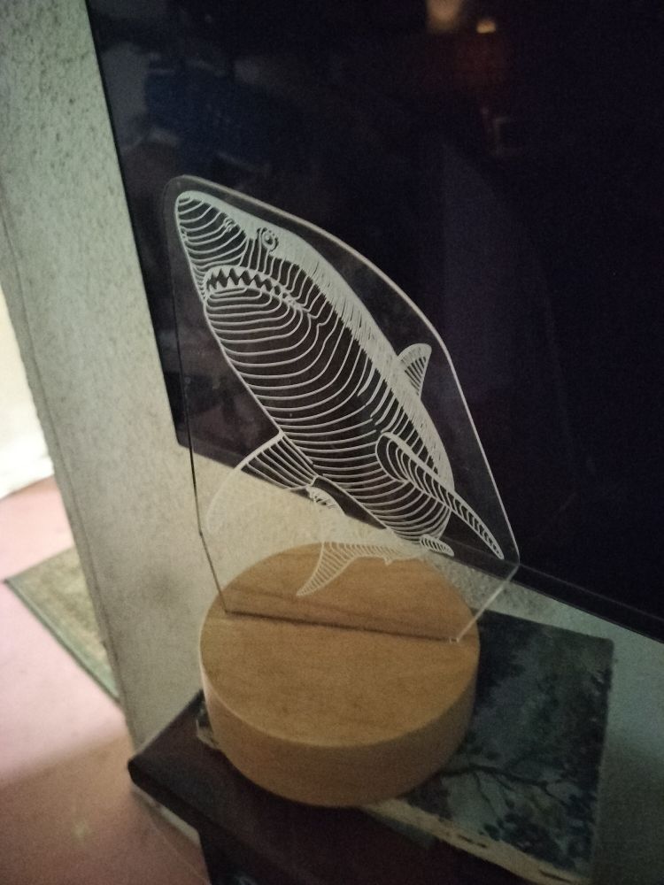 Picture shows a white line shark lamp in front of a tv