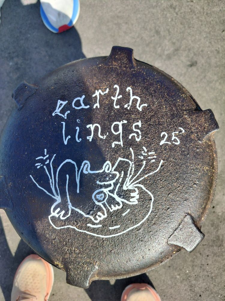 White writing and a drawing of a frog on a pipe cap