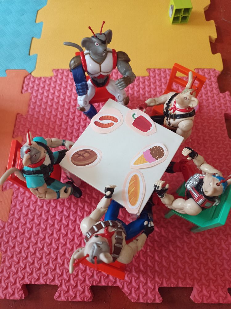 Biker mice seduti a tavola davanti a stickers a forma di cibo