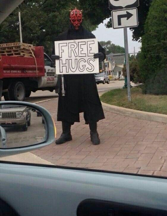 Photo of Darth Maul with a FREE HUGS sign on the side of the road