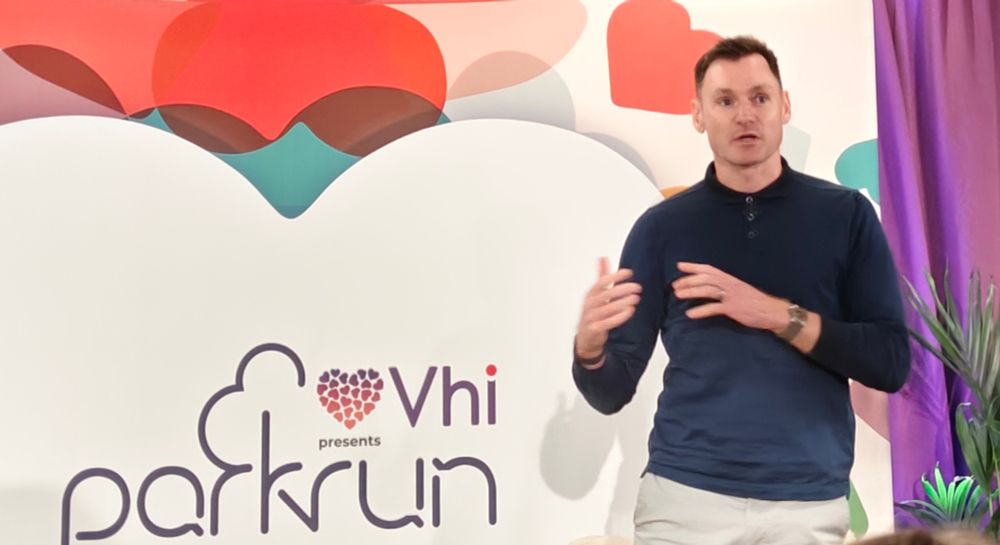 David Gillick, runner, in front of vhi parkrun sign