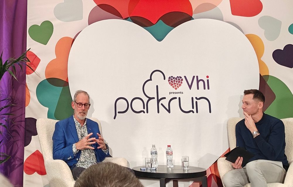 Paul Sinton Hewitt and David Gillick with a vhi parkrun sign,  