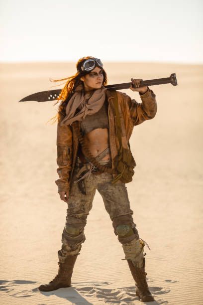 femmine slender person in a desert in the middle of the frame. they have long hair and googles on their forehead. they are wearing a baggy light brown leather jacket, brown scarf, a ripped tank top and brown combat boots. They are holding a spear like weapon and looking off into the distance 