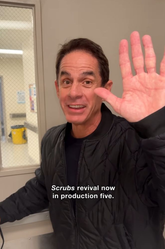 Der Schauspieler des Charakters Todd aus der Serie "Scrubs", der im November 2025 mit einer High Five Geste in Richtung Kamera den Satz "Scrubs revival now oin production five" sagt.