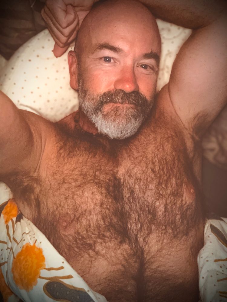 hairy chested man just opening his eyes to greet the day