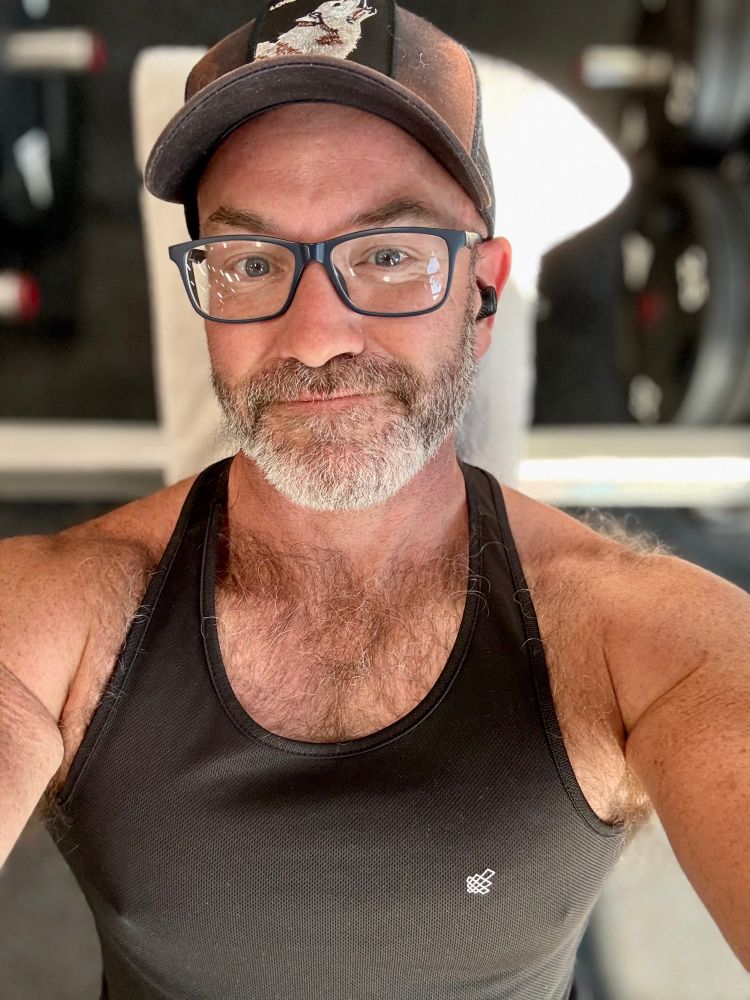 Man in glasses on a barbell bench at the gym