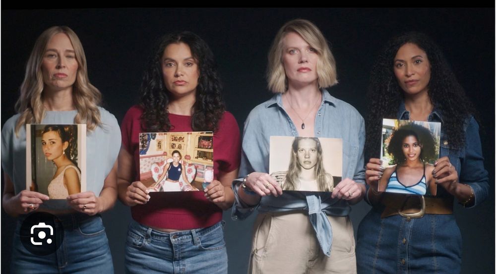 A group of adult survivors stands in a solemn row, each person holding a photo of their younger self. Their expressions are steady and resolute. The contrast between who they are now and the children in the photos underscores both the passage of time and the lasting weight of what they endured. The line of survivors becomes a visual statement of collective strength, testimony, and the demand for justice.