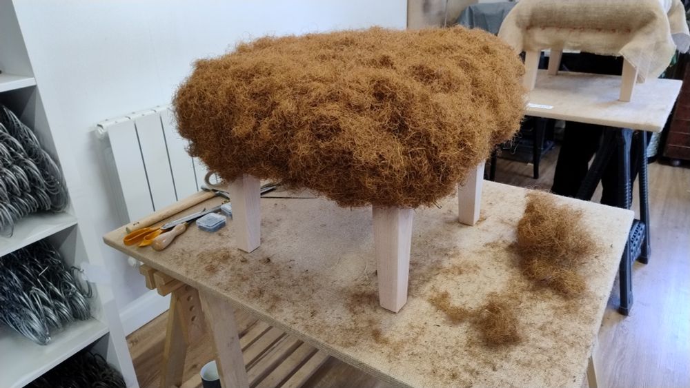 A large amount of coil stuffing fixed to a foot stool.