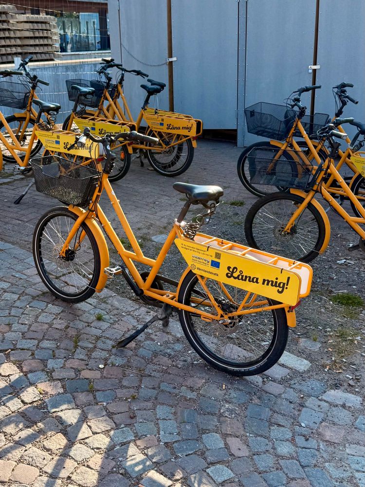 A yellow long tail bike with a large basket up front. 