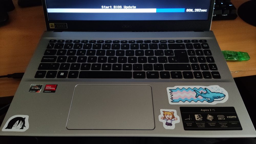 Various stickers beside the laptop touchpad. Tomoko, Neco-arc and a blåhaj