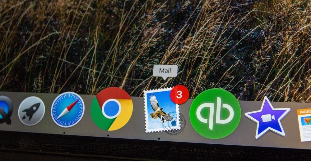 The dock of an Apple computer screen is seen, with the Mail email application signaling three new emails.