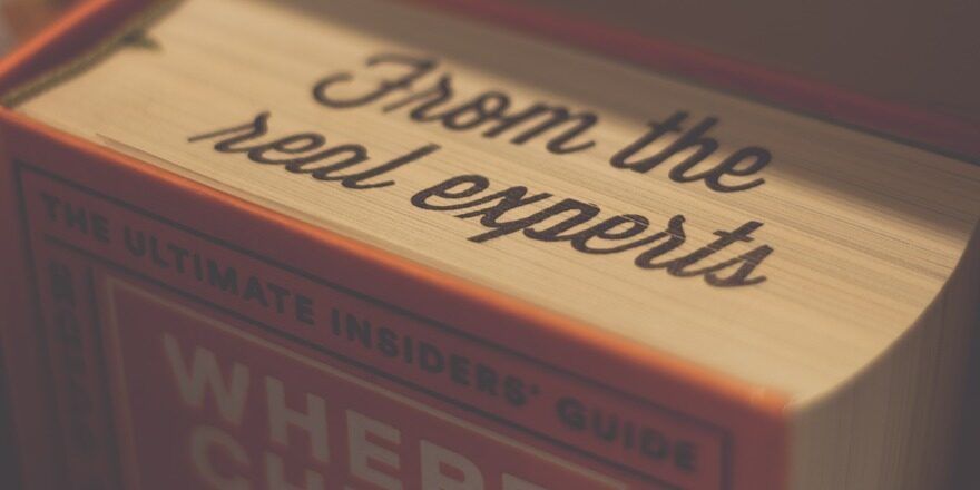"From the real experts" is printed on the edges of the pages in an orange hardcover book.
