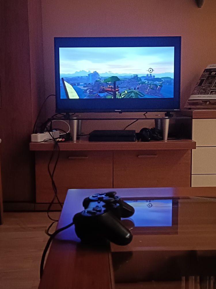 foto de una televisión reproduciendo el videojuego Jak and Daxter. En primer plano, un mando de PlayStation 2 sobre una mesa