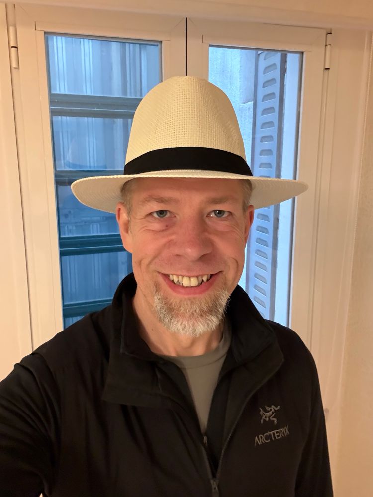 Me wearing a white straw hat with a black band 