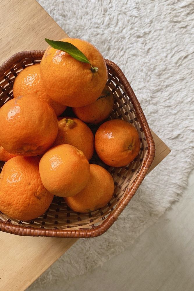 Cesto com bergamotas/tangerinas numa mesa de centro