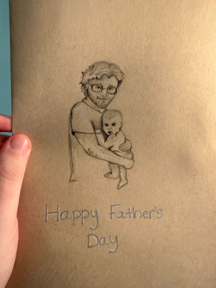 A hand drawn Fathers Day card, with a pencil portrait of me holding our Daughter with the words “Happy Father’s Day” below. Made for me by my amazing wife!