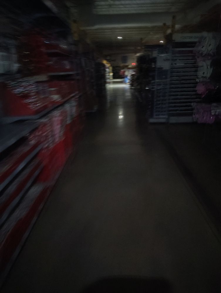 A Walmart isle without any lighting.