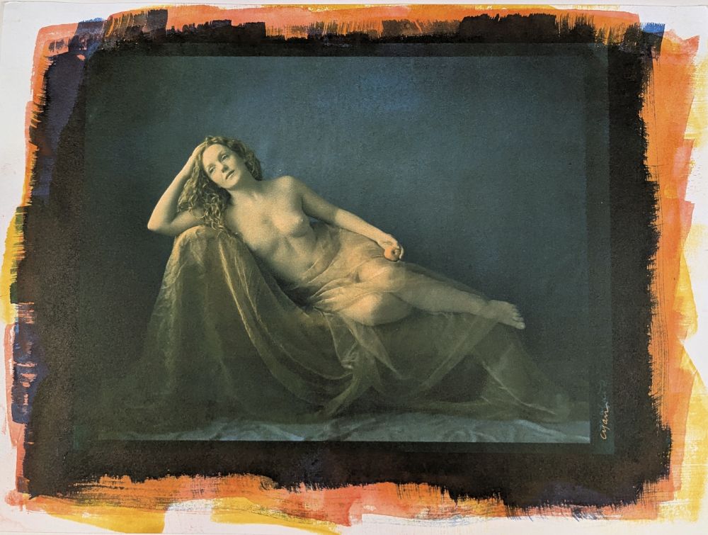 Gum bichromate print of a photograph of model Ivory flame reclining nude on a chaise, holding an apple. You can see the colors from the different layers around the photo.