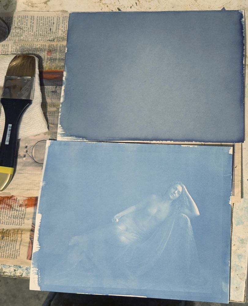 Two sheets of paper coated with cyanotype sensitiver. Both were coated a little over 9 years ago, and kept sort of in the dark. The top sheet shows the unexposed paper, the bottom sheet was exposed with a negative I was working on and developed. It actually showed an image (of model Ivory Flame). I was amazed!