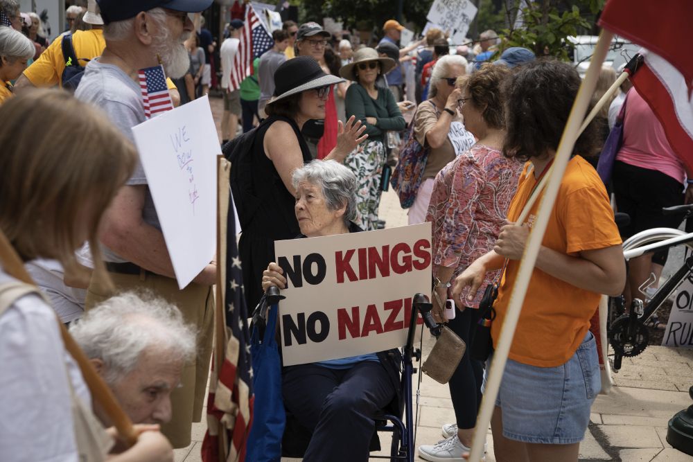 Woman in crowd holding sign 