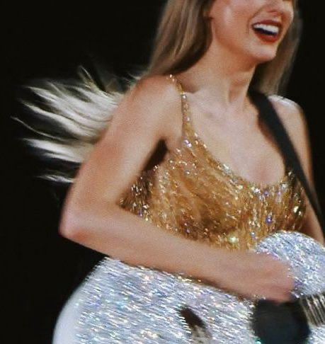 Photo of Taylor Swift in a golden dress with a silver guitar