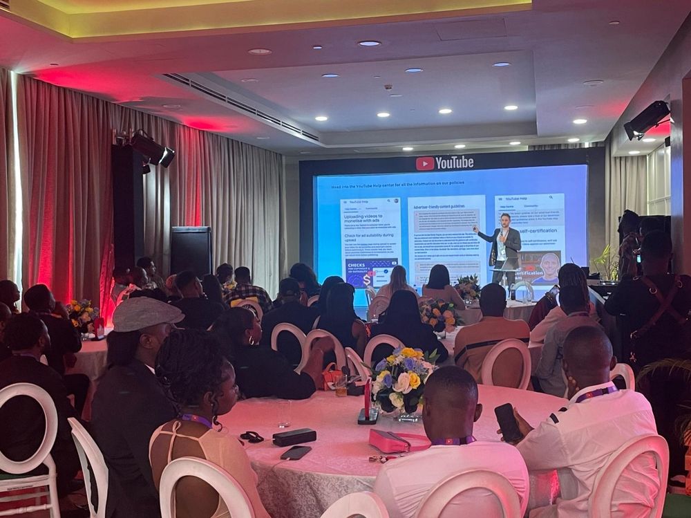 A speaker (Chris Park-Kennaby) presenting to a room of YouTube Creators in Nigeria about advertiser friendly content guidelines