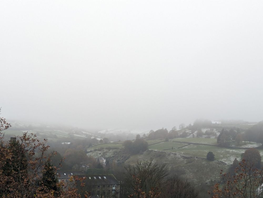 Landscape photo of rolling hills covered in mist on a cold, winter day