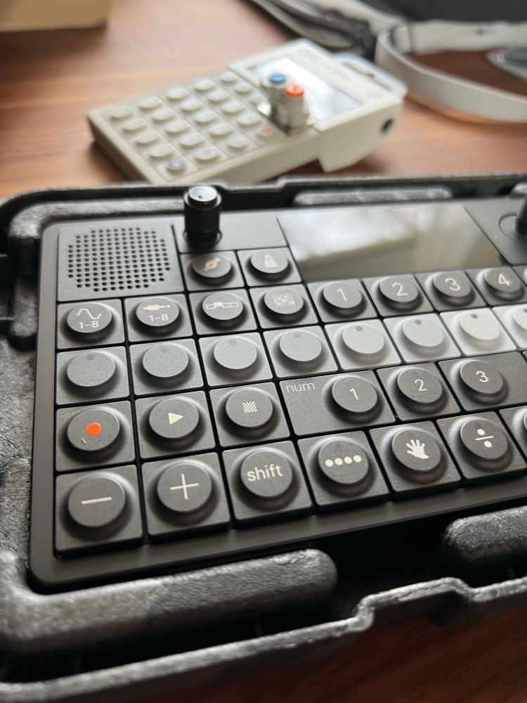 A photo of a grey scale sequencer synthesizer device at an angle-it’s the OP-XY
