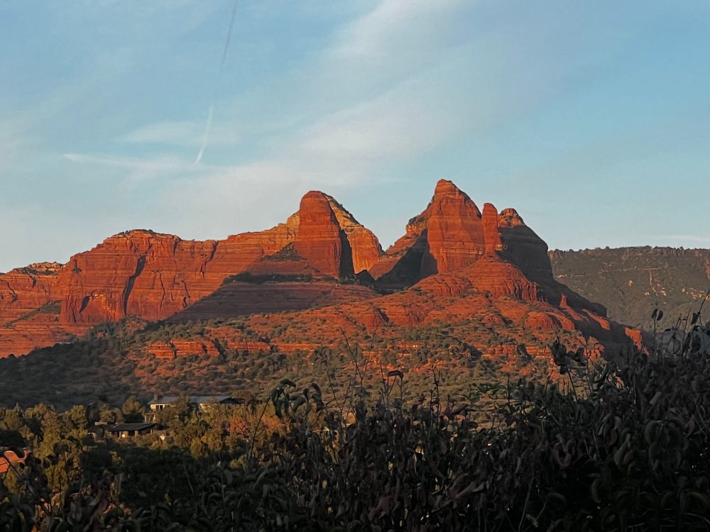 Mountain View of the red rocks of Sedona with sunset shining on it.
