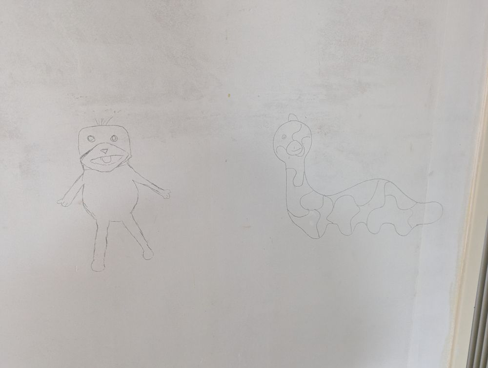 Deux dessins d'enfants sur du placo. 