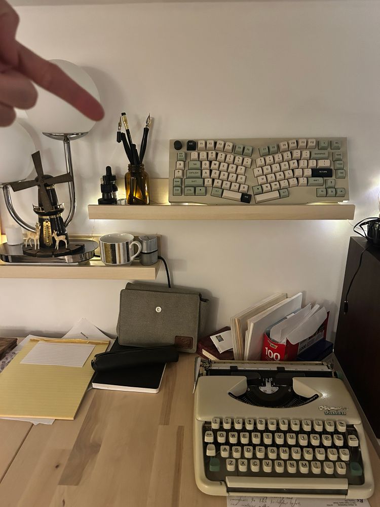 A writing nook with a typewriter, paper and envelopes, dip pens and ink, and two blackwing pencils