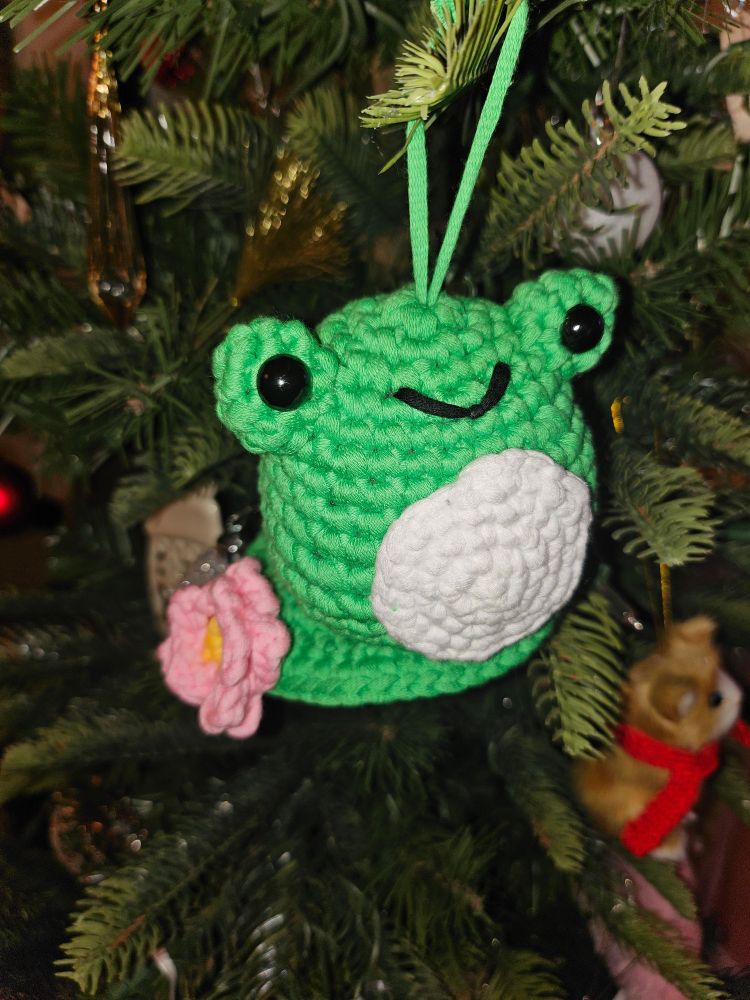 A green frog on a lily pad crocheted from yarn. 
