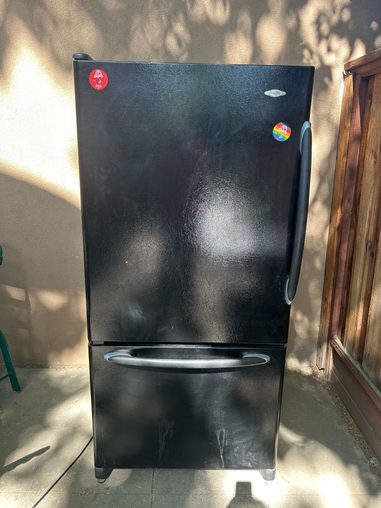 The black fridge, adorned with two DSA stickers