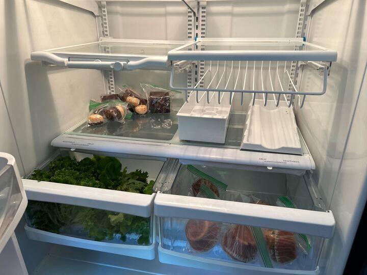 Interior of newly stocked People's Fridge, containing some produce and pastries.