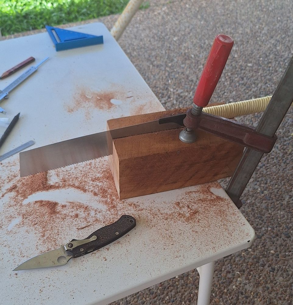 A Japanese dovetail saw about 1/4 of the way through a large block of Queensland Maple.