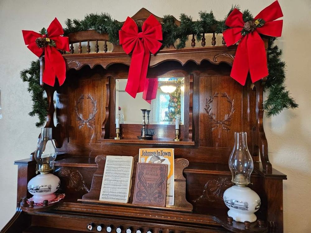 Antique organ decorated with Christmas garland and ribbons.