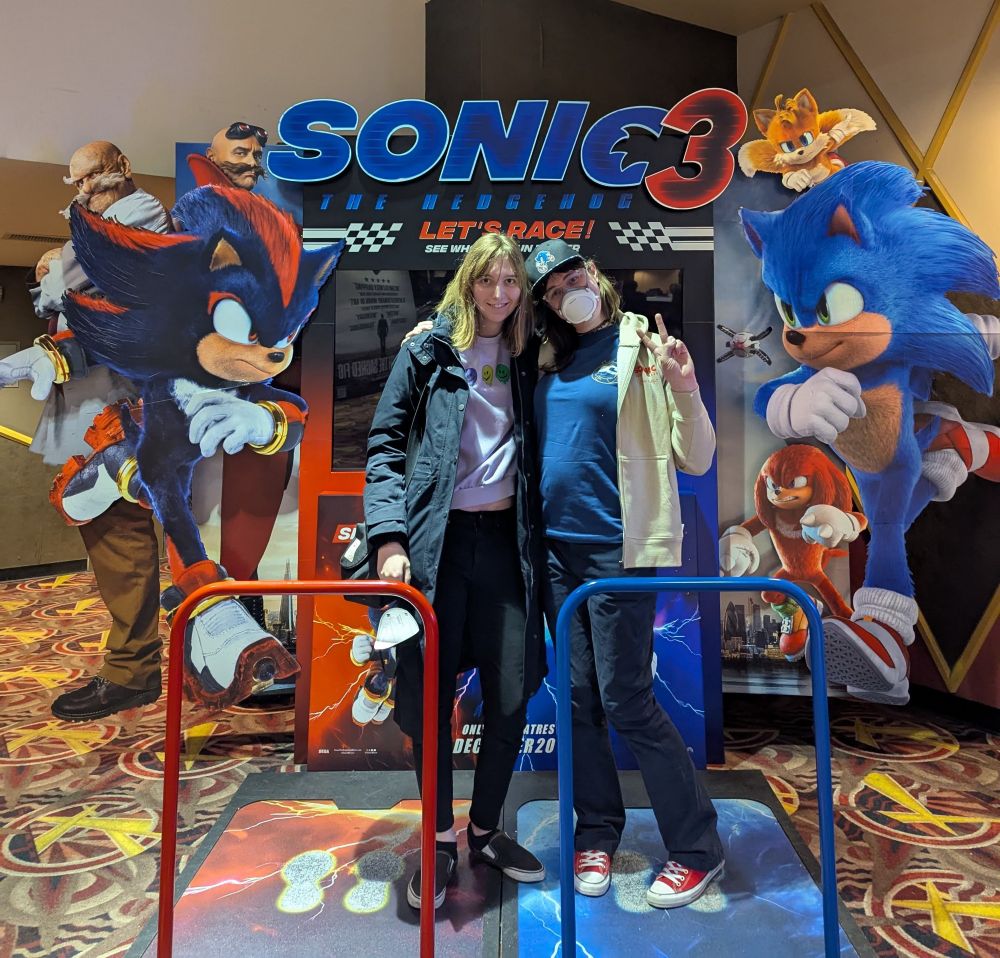 Photo of Norah and Sable in front of the Sonic 3 movie poster at the cinema