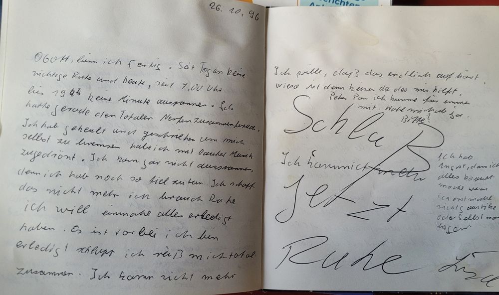 Tagebucheintrag in krakeliger Handschrift: 26.10.96
O Gott, bin ich fertig. Seit Tagen keine richtige Ruhe und heute, seit 7.00Uhr bis 19.45 keine Minute ausspannen. Ich hatte gerade den totalen Nervenzusammenbruch. Ich habe geheult und geschrien. Um mich selbst zu bremsen habe ich mich mit lauter Musik zugedröhnt. Ich kann gar nicht ausrasten, denn ich habe noch so viel zu tun. Ich schaff das nicht mehr, ich brauche Ruhe, ich will einmal alles erledigt haben. Es ist vorbei, ich bin erledigt + schlapp ich reiß mich total zusammen. Ich kann nicht mehr. Ich will, daß das endlich aufhört, warum ist denn keiner da, der mir hilft. Peter Pan, ich komme für immer mit. Hole mich ab, ja. Bitte!
Ich habe Angst, dass ich alles kaputt mache, wenn ich erst mal richtig austricke oder selbst man digen (schlecht lesbar)
In Großbuchstaben über die ganze Seite: Schluss jetzt Ruhe!