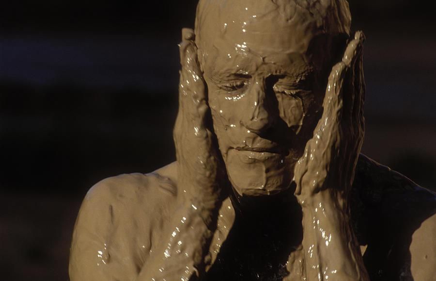 Someone covering their face with mud