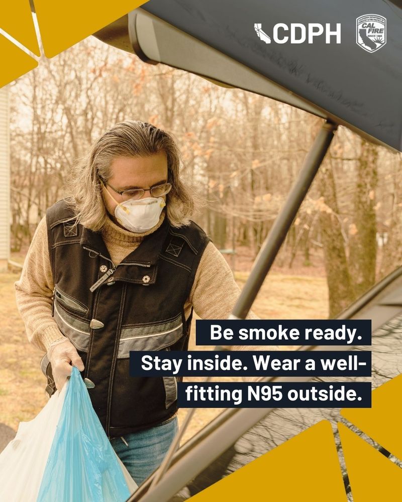 A person wearing a mask outdoors and holding a blue bag. "Be smoke ready. Stay inside. Wear a well-fitting N95 outside."