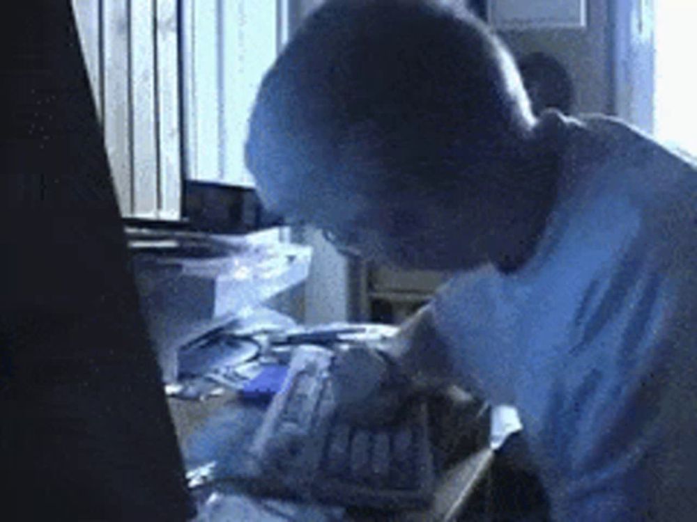 a man in a white shirt is working on a computer