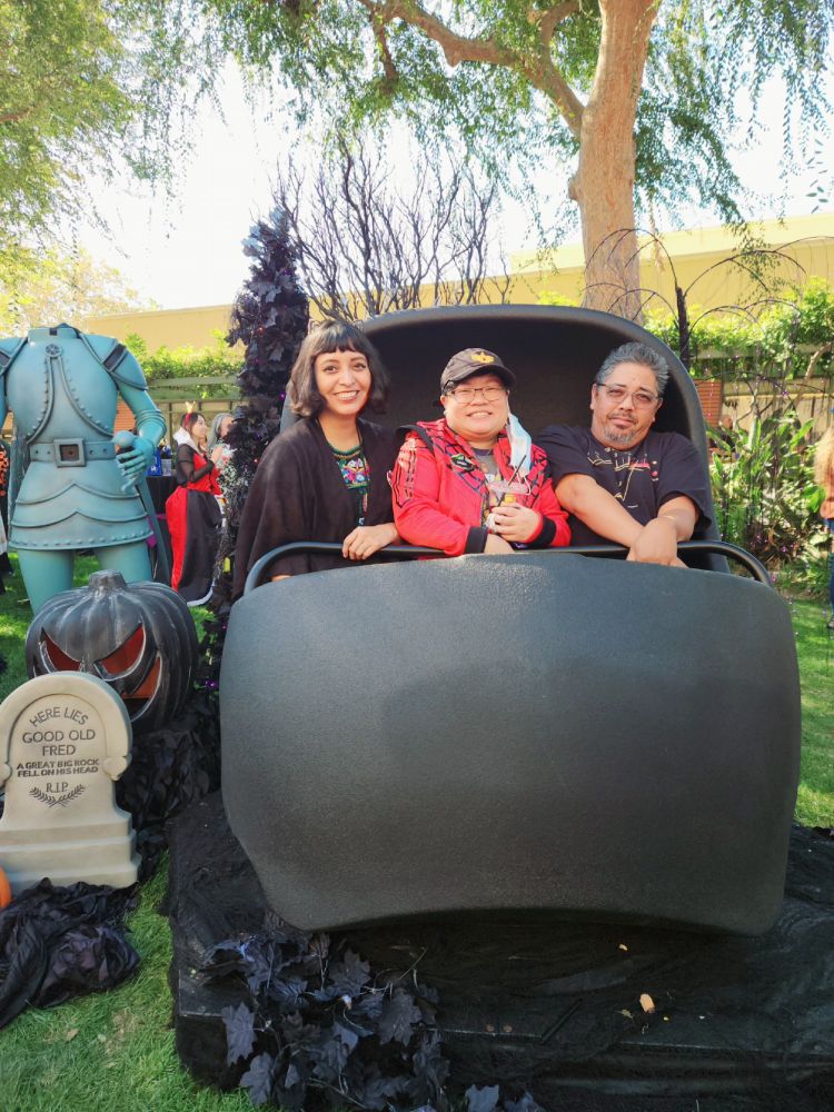 Photo of three friends on a Disneyland Haunted Mansion doom buggy in an outdoor setting