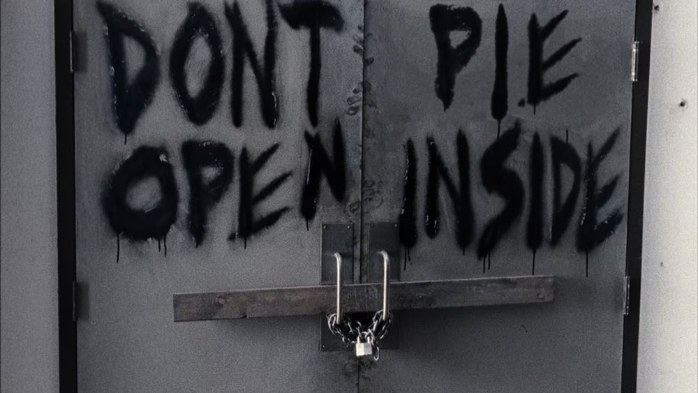 There is a scary door. The words "Don't pie, open inside" are spray-painted on it