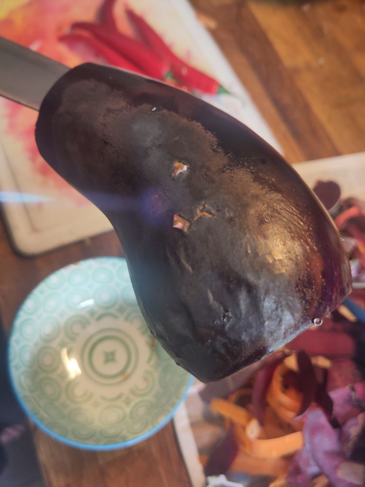 An aubergine being blowtorched