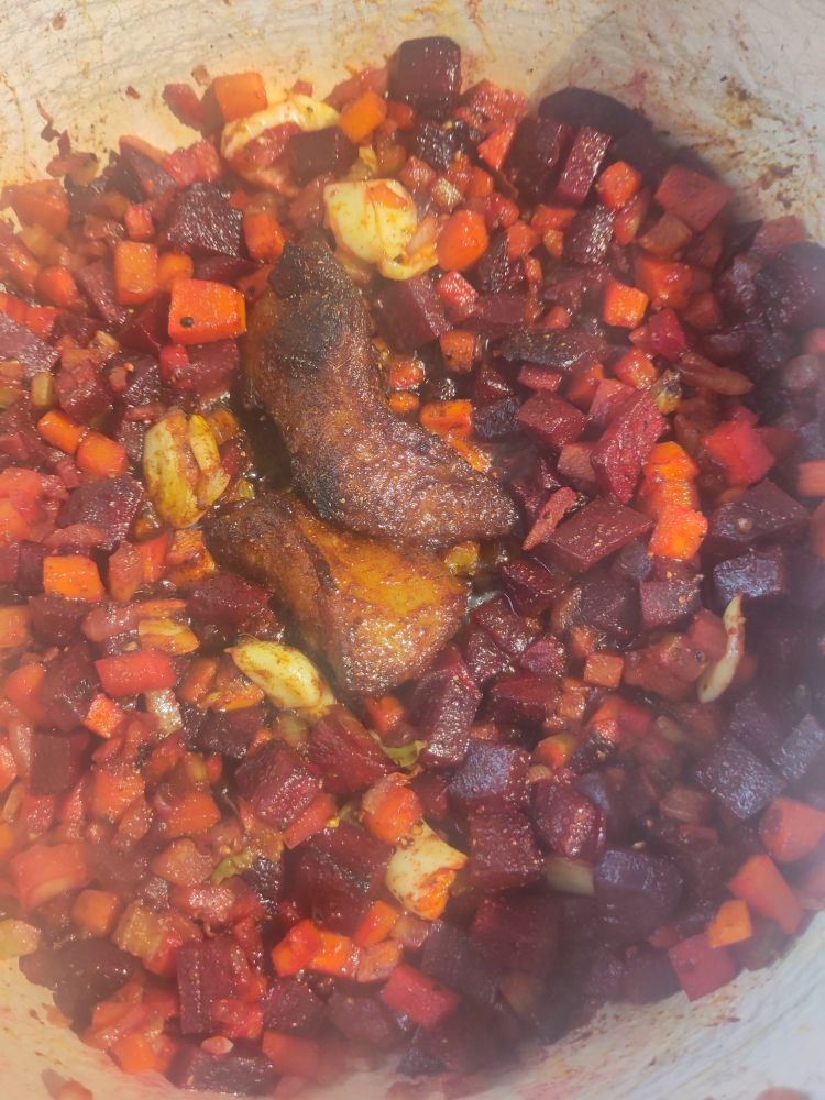 The pot with veg cooked off beetroot added and the fat rendered down a lot 