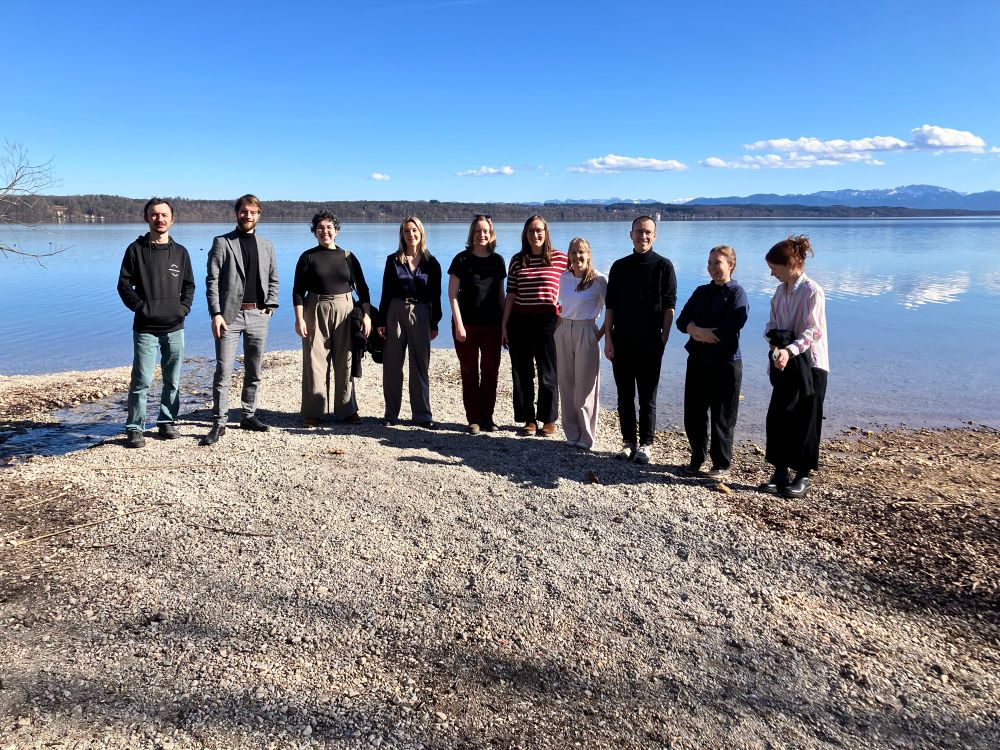 Ten people in front of a lake 