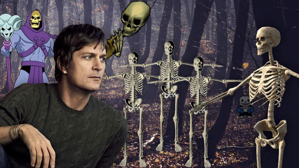 Rob Thomas surrounded by skeletons in a spooky forest