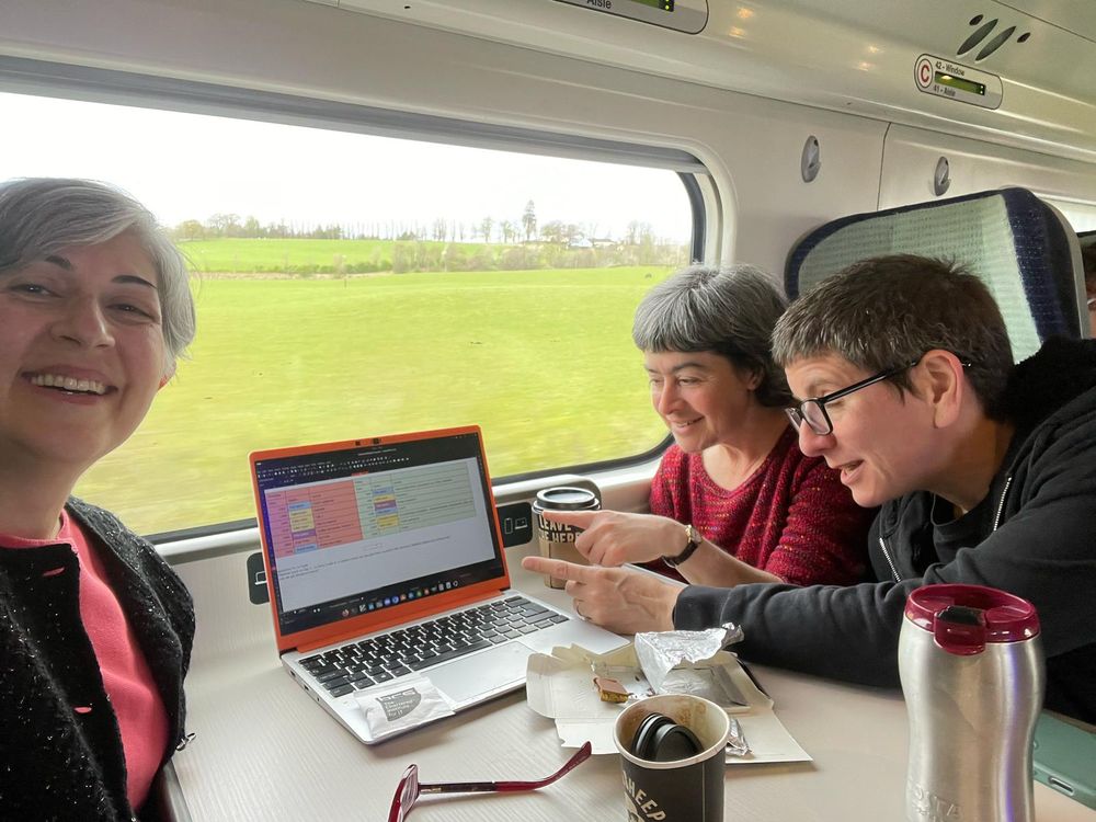 Safia, Hannah and Amanda planning the Lovelace Colloquium timetable on a laptop on a train. 