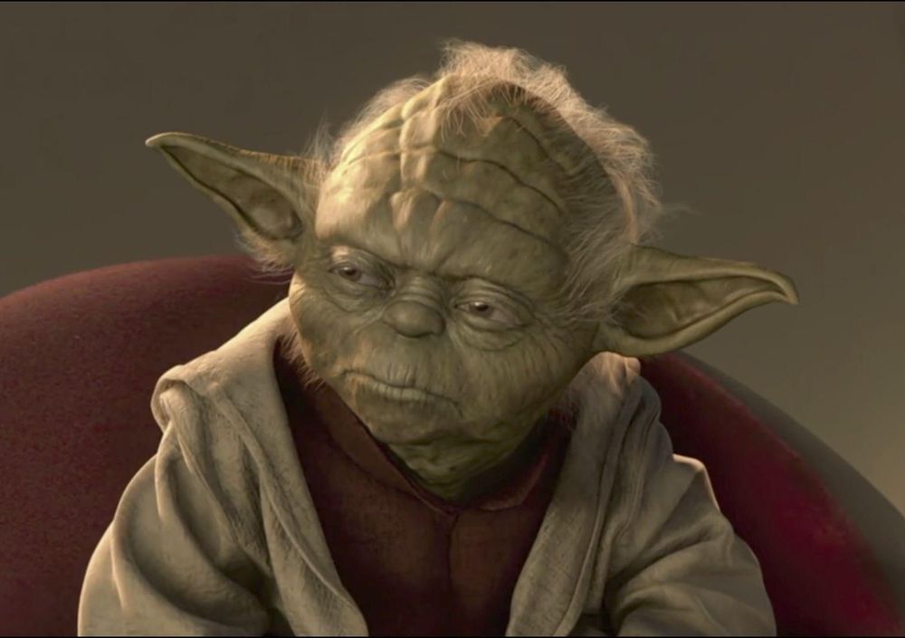 Yoda in the Jedi Council, looking pensive.